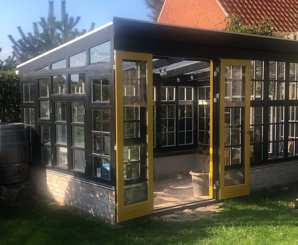 Orangeri laget av resirkulerte murstein, dører og vinduer Orangeri laget av resirkulerte murstein, dører og vinduer